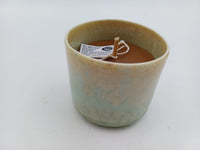Three-quarter view of seafoam green pottery candle
