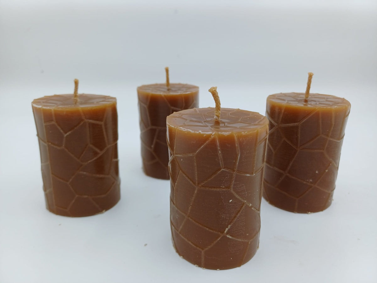 Four beeswax pillars with mosaic-like geometric surface pattern