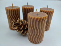 Close-up of sculptural wave-textured beeswax candles