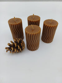 Four wavy beeswax pillars with pinecone decoration